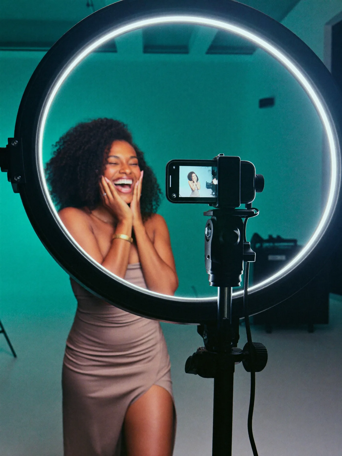 Criadora de conteúdo sorrindo diante de ring light em estúdio